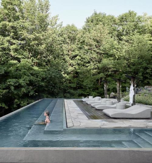 Outdoor pool surrounded by forest at BALNEA - Balnea Spa